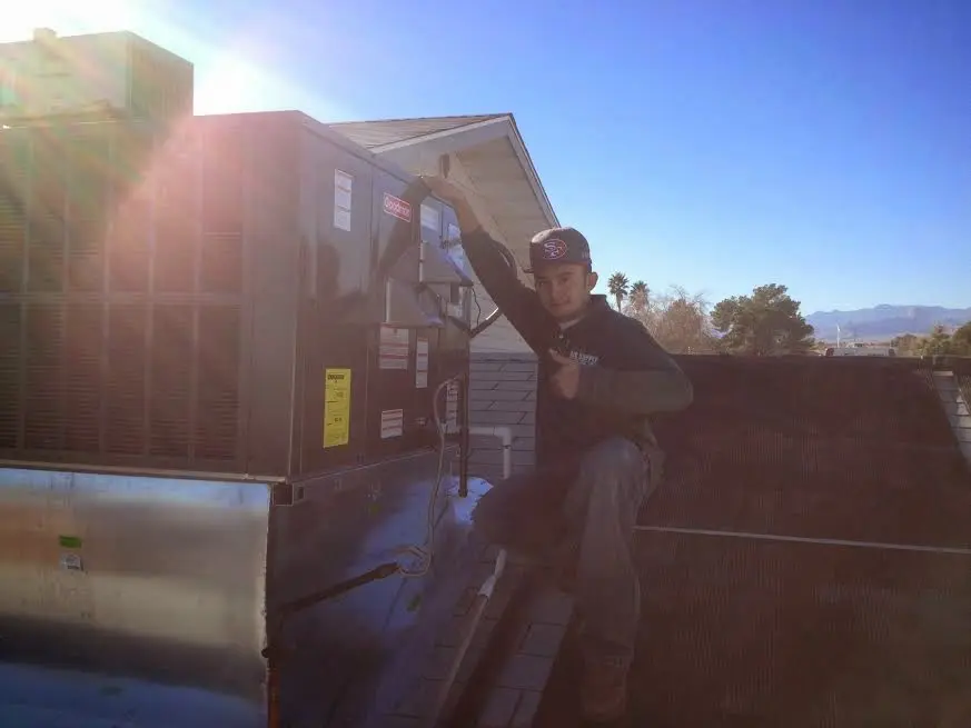 HVAC technician performing Boiler Repair on a rooftop unit in Suwanee